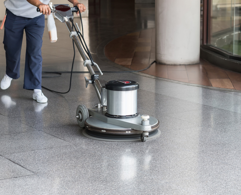 Woman cleaning the floor with polishing machine