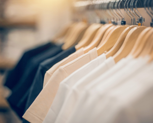 T-shirts on hangers. Shopping in store. Clothes on hangers in shop for sale