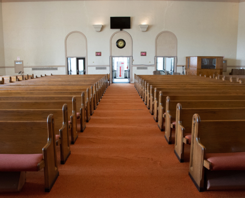 wide angle shot of interior of empty church lit by faint sunlight