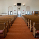 wide angle shot of interior of empty church lit by faint sunlight